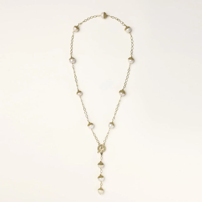 Gold-plated lariat necklace with baroque pearls and textured caps on cream background, showing adjustable Y-shaped design.