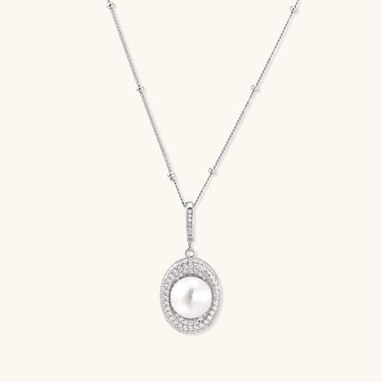 Oval sterling silver pendant with crystal halo surrounding a white freshwater pearl on delicate chain