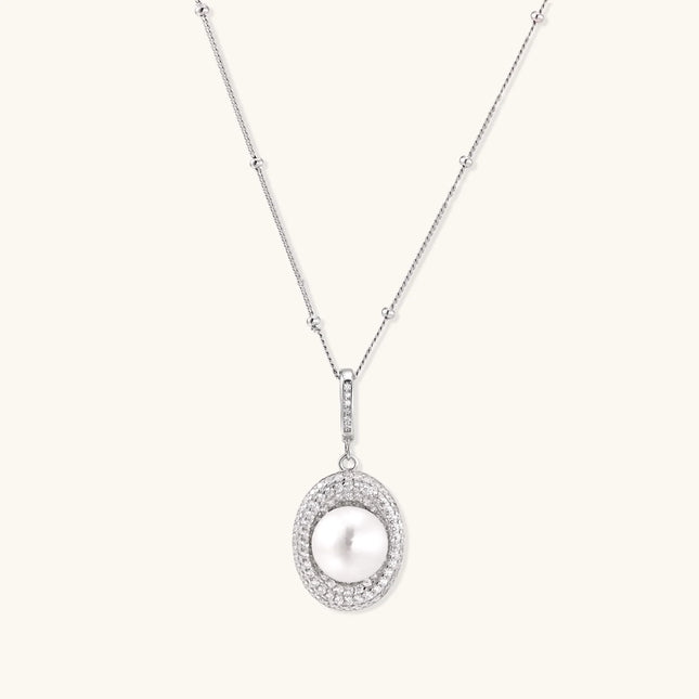 Oval sterling silver pendant with crystal halo surrounding a white freshwater pearl on delicate chain