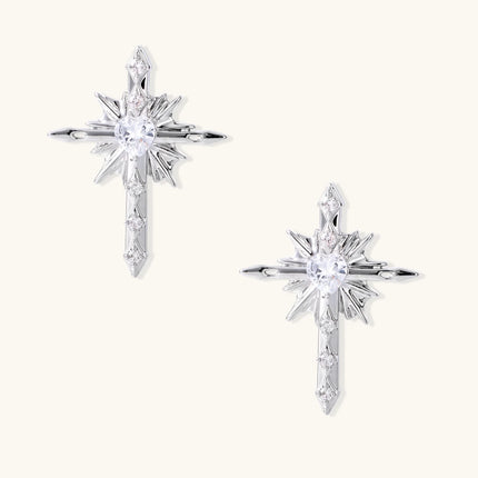 Silver starburst earrings with radiating points and dagger drop design featuring clear zirconia stones