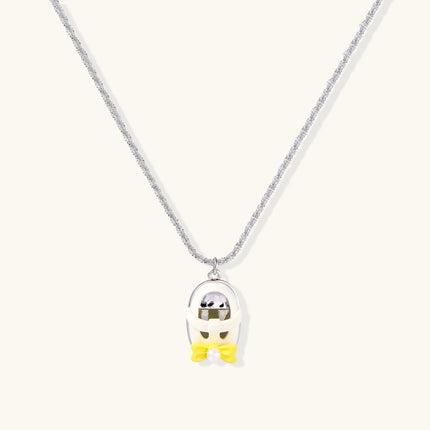 Chrome egg-shaped pendant with kawaii face, yellow bow, and pearl detail on silver chain against white background