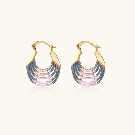 Gold hoop earrings with gradient blue-to-pink enamel in ribbed fan design on beige background