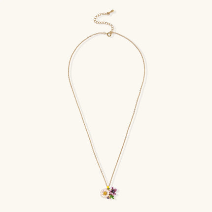 Gold-plated necklace with pink and purple enamel flower pendant featuring crystal accents on cream background