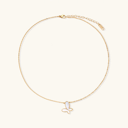 Gold-plated butterfly pendant with iridescent mother of pearl inlay on delicate chain against cream background.