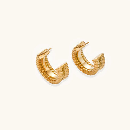 Chunky gold hoops with dimensional ridged texture and 14K plated finish shown in front and side view on cream background.