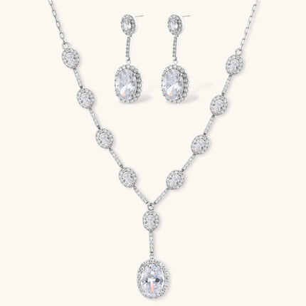 Elegant white gold plated jewelry set with oval cubic zirconia stones in halo settings, featuring Y-necklace and drop earrings.