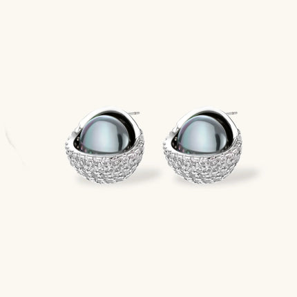 Elegant spherical pendant necklace and earrings set featuring crystal-pavé bottom half in gold or silver finish on white background.