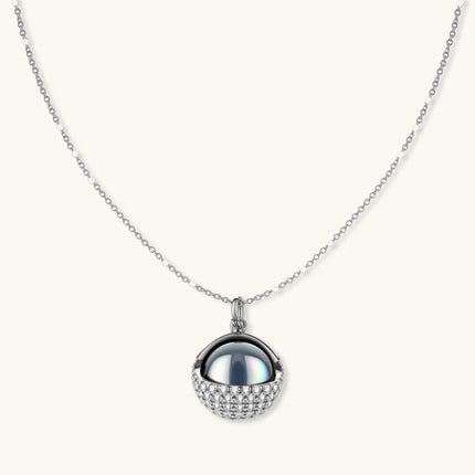 Elegant spherical pendant necklace and earrings set featuring crystal-pavé bottom half in gold or silver finish on white background.