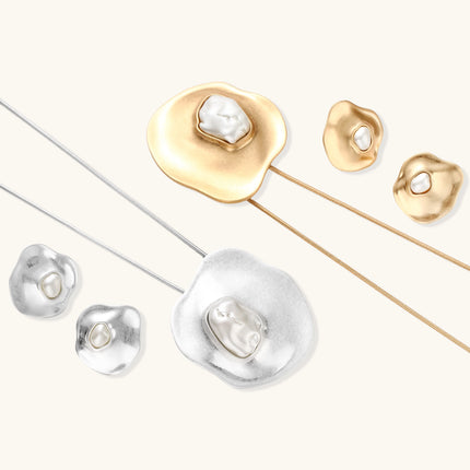 Organic-shaped gold pendant necklace with baroque pearl accent on adjustable chain, displayed against neutral background.